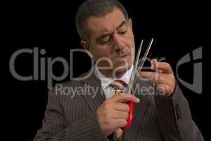 Businessman cutting nails with huge scisors