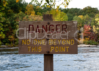 Danger sign by river