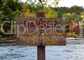 Danger sign by river