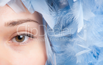 Girl posing with blue feathers