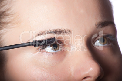 Beautiful woman putting make up on eye