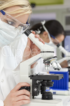 Female Scientific Research Team Using Microscopes in a Laborator