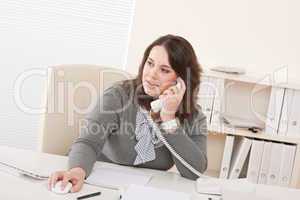 Young business woman on phone at office