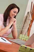 Smiling businesswoman with laptop at office