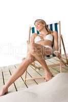 Beach - woman in bikini lying on deck chair