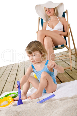 Beach - Mother with child playing with toys in sand