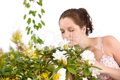 Portrait of woman smelling blossom of Rhododendron flower