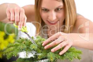 Gardening - woman trimming spruce tree, focus on scissors