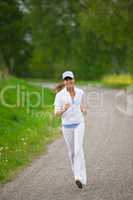 Jogging - sportive woman running on road in nature