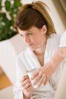 Young woman in white bathrobe with coffee