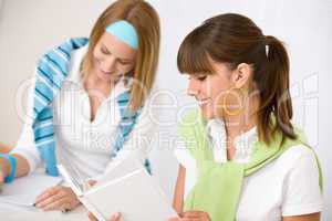 Student at home - two young woman study together