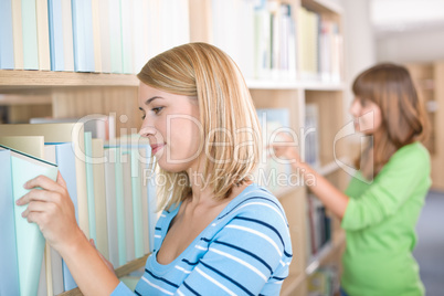 Student in library - two woman search for book