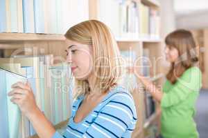 Student in library - two woman search for book
