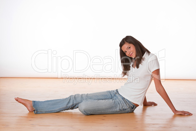 Happy teenager sitting on wooden floor