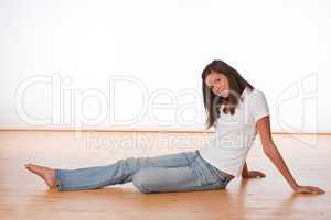 Happy teenager sitting on wooden floor