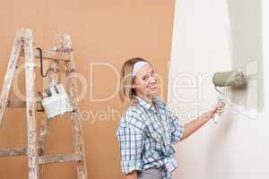 Home improvement: Happy woman painting wall