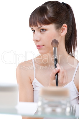 Body care: Young woman applying powder with brush