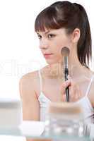 Body care: Young woman applying powder with brush