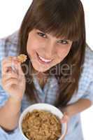 Smiling female teenager eat healthy cereal for breakfast
