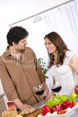 Happy couple drink red wine in modern kitchen