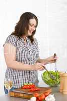 Cook - Plus size happy woman preparing salad