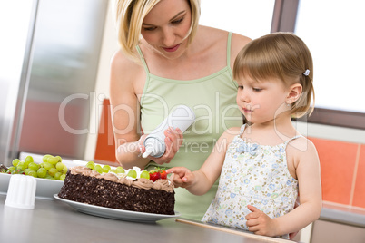 Mother and child with chocolate cake in kitchen