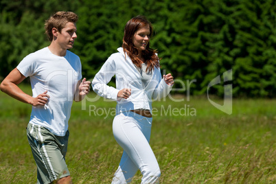 Young couple jogging outdoors in spring nature