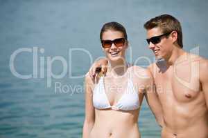Happy couple in swimwear at sea in summer