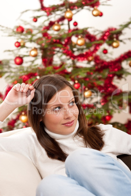 Young woman sitting in front of Christmas tree