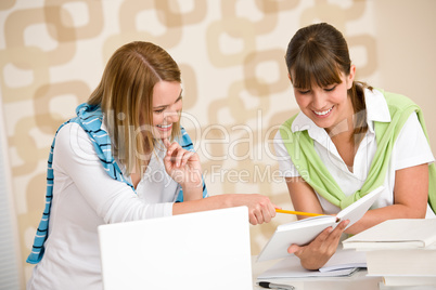 Student at home - two woman with book and laptop