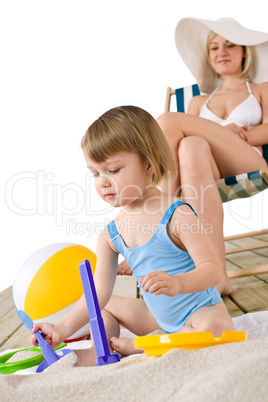 Beach - Mother with child playing with toys in sand