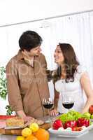 Happy couple drink red wine in modern kitchen