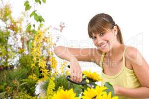 Gardening - woman cutting sunflower with pruning shears