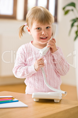 Smiling little girl on phone in lounge