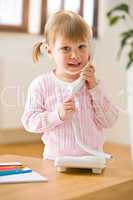 Smiling little girl on phone in lounge
