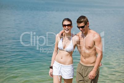 Happy couple in swimwear at sea enjoy sun