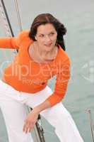 Attractive woman standing on sailing boat with headphones