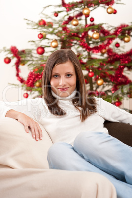 Young woman sitting in front of Christmas tree