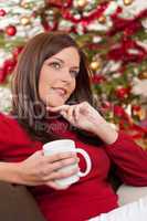 Brown hair woman relaxing in front of Christmas tree