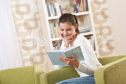 Students - Happy teenager with book sitting on armchair