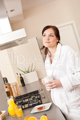 Young woman enjoying coffee in modern kitchen