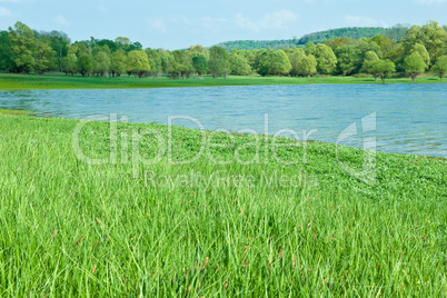 Green meadows with natural mountain lake