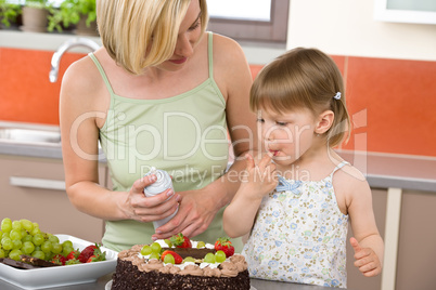 Mother and child with chocolate cake in kitchen