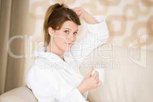 Young woman in white bathrobe with coffee