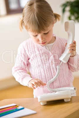 Little girl dial number on phone in lounge