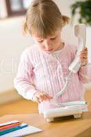 Little girl dial number on phone in lounge