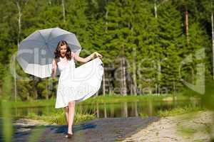 Happy romantic woman with parasol in sunlight