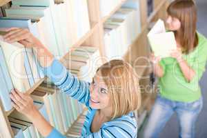 Student in library - two woman choose book