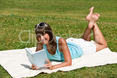 Smiling young woman read book in park