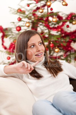 Young woman sitting in front of Christmas tree